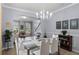 Open dining room has neutral paint, a chandelier, and glass table with white chairs at 27549 Stonecreek Way, Wesley Chapel, FL 33544