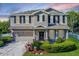 Charming two-story home with a well-manicured lawn, black shutters, and a welcoming front porch at 27549 Stonecreek Way, Wesley Chapel, FL 33544