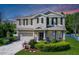 Charming two-story home with a well-manicured lawn, black shutters, and a welcoming front porch at 27549 Stonecreek Way, Wesley Chapel, FL 33544