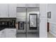 Close-up of stainless steel refrigerator with smart screen, set amongst white cabinets and sleek countertops at 27549 Stonecreek Way, Wesley Chapel, FL 33544