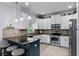 Bright kitchen boasts white cabinets, stainless steel appliances, and breakfast bar seating at 27549 Stonecreek Way, Wesley Chapel, FL 33544