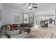 Open-concept living room featuring a gray sectional sofa, and a view into the kitchen at 27549 Stonecreek Way, Wesley Chapel, FL 33544