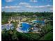 Aerial view of a community pool with lush landscaping, waterslide and palm trees at 27549 Stonecreek Way, Wesley Chapel, FL 33544
