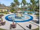Overhead view of a splash pad with surrounding lounge chairs and tables with umbrellas at 27549 Stonecreek Way, Wesley Chapel, FL 33544