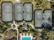 Aerial view of tennis courts and a community pool surrounded by lush greenery at 27549 Stonecreek Way, Wesley Chapel, FL 33544