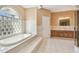 Bathroom featuring a soaking tub with glass block window and vanity at 284 Peninsula Ave, Tarpon Springs, FL 34689