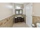Bathroom featuring decorative tiles, modern vanity, framed mirror, and toilet with tiled floors at 284 Peninsula Ave, Tarpon Springs, FL 34689