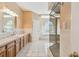 Bathroom with oak cabinets, tiled floors, bathtub and glass shower at 284 Peninsula Ave, Tarpon Springs, FL 34689