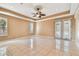 Bright bedroom featuring a ceiling fan, two windows, and private balcony access at 284 Peninsula Ave, Tarpon Springs, FL 34689