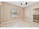 Bright bedroom featuring tile flooring, ceiling fan, and a window with a view to the outside at 284 Peninsula Ave, Tarpon Springs, FL 34689