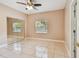 Bright bedroom featuring tile flooring, ceiling fan, mirrored closet, and a window with a view to the outside at 284 Peninsula Ave, Tarpon Springs, FL 34689