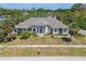 An aerial view shows a beautifully landscaped property with a well-maintained lawn, and welcoming front entrance at 284 Peninsula Ave, Tarpon Springs, FL 34689