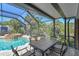 Outdoor patio under a screened enclosure provides an expansive view of the pool and surrounding natural landscape at 284 Peninsula Ave, Tarpon Springs, FL 34689