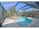 Backyard pool area featuring a jacuzzi, screened in enclosure, and outdoor grill with dining set at 284 Peninsula Ave, Tarpon Springs, FL 34689