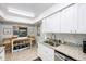 Bright kitchen featuring granite countertops, white cabinets, stainless steel appliances, and ample natural light at 2900 Cove Cay Dr # 1B, Clearwater, FL 33760