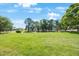 View of the expansive green lawn surrounded by mature trees, ideal for outdoor activities at 2900 Cove Cay Dr # 1B, Clearwater, FL 33760