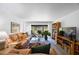 Bright living room featuring a plush leather sofa, large windows with sheer curtains, and built-in bookshelves at 2900 Cove Cay Dr # 1B, Clearwater, FL 33760