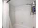 White shower and bathtub with showerhead and toiletries holder at 2900 Cove Cay Dr # 1B, Clearwater, FL 33760