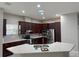 Well-lit kitchen featuring stainless steel appliances, granite countertops, and dark wood cabinets at 29823 Ganga Way, Wesley Chapel, FL 33543