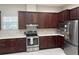 Spacious kitchen with stainless steel appliances, granite countertops, and classic dark cabinetry at 29823 Ganga Way, Wesley Chapel, FL 33543
