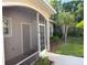 View of the screened front porch and entryway complemented by manicured landscaping and mature trees at 29823 Ganga Way, Wesley Chapel, FL 33543