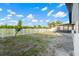 Large backyard featuring a white fence, green trees, and an enclosed pool area at 3139 Elkridge Dr, Holiday, FL 34691