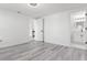 Open doorway to a full bath and kitchen is showcased in this bright bedroom featuring wood-look floors and fresh white paint at 3139 Elkridge Dr, Holiday, FL 34691