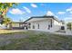 View of backyard on a sunny day, showing the home's stucco exterior at 3139 Elkridge Dr, Holiday, FL 34691
