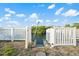 A white fence with a gate that offers waterfront access at 3139 Elkridge Dr, Holiday, FL 34691