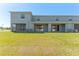 Home's backyard with a lush lawn, patio area, and sliding glass doors leading to the interior at 33105 Major Oak Dr, Wesley Chapel, FL 33545