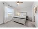 Bright bedroom featuring a white bed frame, large window, and ceiling fan at 33105 Major Oak Dr, Wesley Chapel, FL 33545