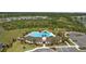 Aerial view of community pool and clubhouse with palm trees and ample seating at 33105 Major Oak Dr, Wesley Chapel, FL 33545
