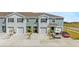 Townhomes with gray exteriors, one-car garages, tidy landscaping, and ample parking at 33105 Major Oak Dr, Wesley Chapel, FL 33545