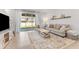 Bright living room with tile floors, a plush sofa, and sliding glass doors to the backyard at 33105 Major Oak Dr, Wesley Chapel, FL 33545