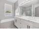 Stylish bathroom with double vanities, a soaking tub, and a glass-enclosed shower for a spa-like experience at 3326 W Heiter St, Tampa, FL 33607