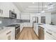 Modern kitchen with white cabinets, stainless steel appliances, and a kitchen island with white countertops at 3326 W Heiter St, Tampa, FL 33607