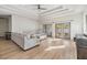 Bright living room with wood flooring, a ceiling fan, and sliding glass doors to the outside at 3326 W Heiter St, Tampa, FL 33607