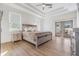 Main bedroom with tray ceiling, fan, laminate flooring, and french door to patio at 3326 W Heiter St, Tampa, FL 33607