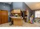 Bright kitchen with tile floors, wood cabinetry, breakfast bar, and stainless appliances at 35109 Excalibur, Webster, FL 33597