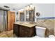 Bathroom featuring double sinks, granite counters, wood cabinets, and blue accent tile at 422 Dunedin Cir, Temple Terrace, FL 33617