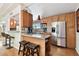 Updated kitchen featuring granite countertops, a kitchen island with bar stools, and stainless steel refrigerator at 422 Dunedin Cir, Temple Terrace, FL 33617