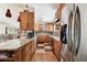 Galley kitchen with stainless steel appliances, warm wood cabinets, and granite counters that offers an efficient layout at 422 Dunedin Cir, Temple Terrace, FL 33617