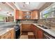 Well-lit kitchen with stainless steel appliances, tiled backsplash, and marble countertops by the window at 422 Dunedin Cir, Temple Terrace, FL 33617