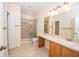 This bathroom showcases a shower, toilet, vanity area, large mirror, and neutral colored walls at 4235 Angelica Loop, Wesley Chapel, FL 33543
