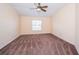 Large, carpeted bedroom with a ceiling fan, window and a bright, neutral color scheme at 4235 Angelica Loop, Wesley Chapel, FL 33543