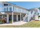 Elevated home with a light-blue metal roof, and a large deck supported by white pillars at 4275 Bellaire Dr, Hernando Beach, FL 34607