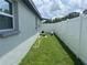 Fenced backyard with green grass and a small scooter visible on the side of the house at 4503 W Minnehaha St, Tampa, FL 33614