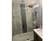 Modern bathroom with glass shower door, gray marble-style tiles, and a showerhead at 4503 W Minnehaha St, Tampa, FL 33614
