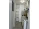Compact kitchen with white cabinets, a sink, mosaic backsplash, and open shelving at 4503 W Minnehaha St, Tampa, FL 33614