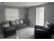 Inviting living room with tile floors, a gray sectional sofa, and natural light from the blinds at 4503 W Minnehaha St, Tampa, FL 33614